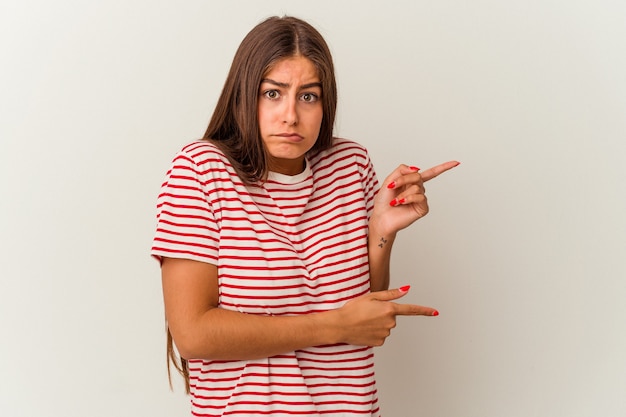 Young caucasian woman isolated on white background thoughtful looking to a copy space covering mouth with hand.