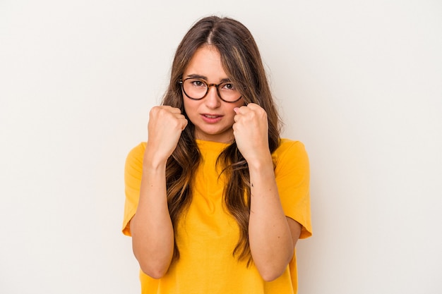 Young caucasian woman isolated on white background upset screaming with tense hands.