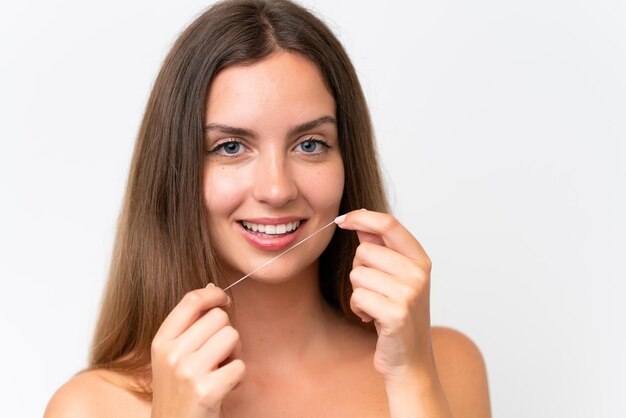 Young caucasian woman isolated on white background using dental floss with happy expression Close up portrait