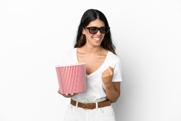 Young caucasian woman isolated on white background with 3d glasses and holding a big bucket of popcorns while looking side