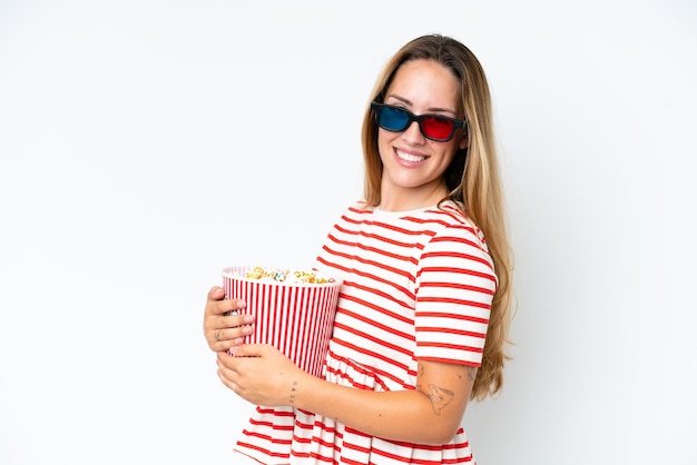 Young caucasian woman isolated on white background with 3d glasses and holding a big bucket of popcorns