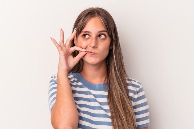 Young caucasian woman isolated on white background with fingers on lips keeping a secret.