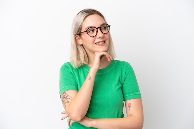 Young caucasian woman isolated on white background With glasses and thinking while looking up