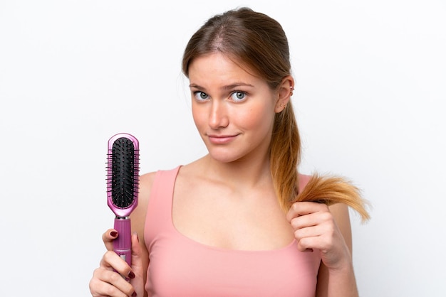 Young caucasian woman isolated on white background with hair comb