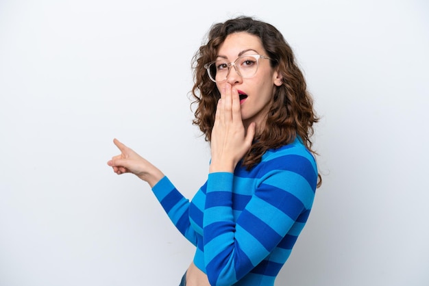 Young caucasian woman isolated on white background with surprise expression while pointing side