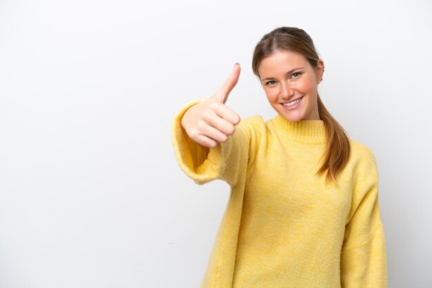 Young caucasian woman isolated on white background with thumbs up because something good has happened