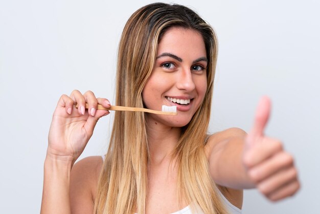 Young caucasian woman isolated on white background with a toothbrush