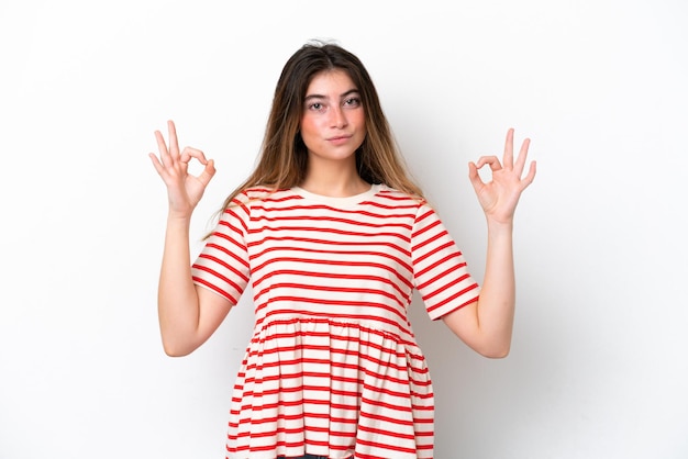 Young caucasian woman isolated on white background in zen pose