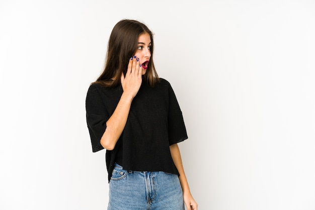 Young caucasian woman isolated on white being shocked because of something she has seen.