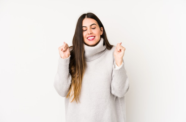 Young caucasian woman isolated on white raising fist, feeling happy and successful. Victory concept.