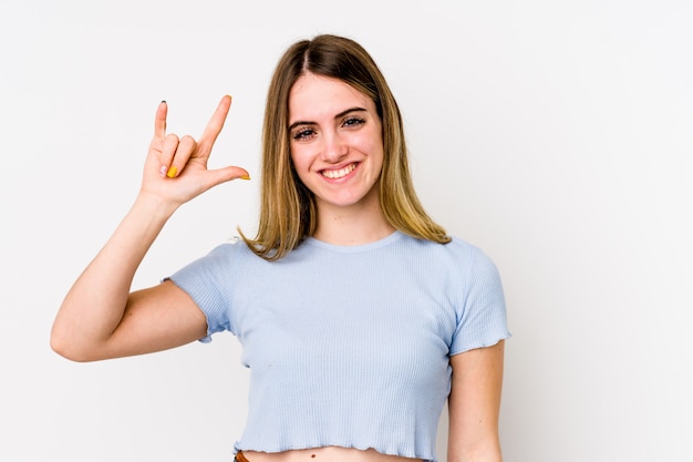 Young caucasian woman isolated on white showing a horns gesture as a revolution concept.