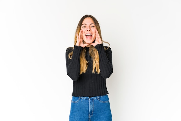 Young caucasian woman isolated on white space shouting excited to front.