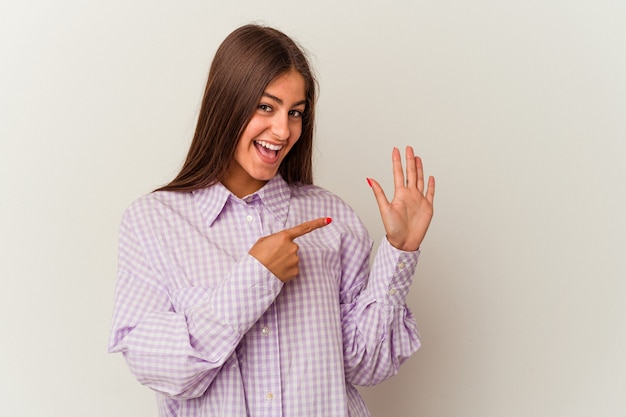 Young caucasian woman isolated on white wall laughing about something, covering mouth with hands.