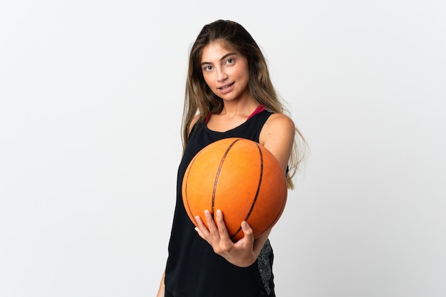 Giovane donna caucasica isolata sul muro bianco, giocando a basket