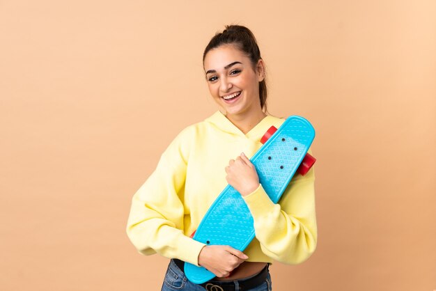 Photo young caucasian woman isolated with a skate with happy expression