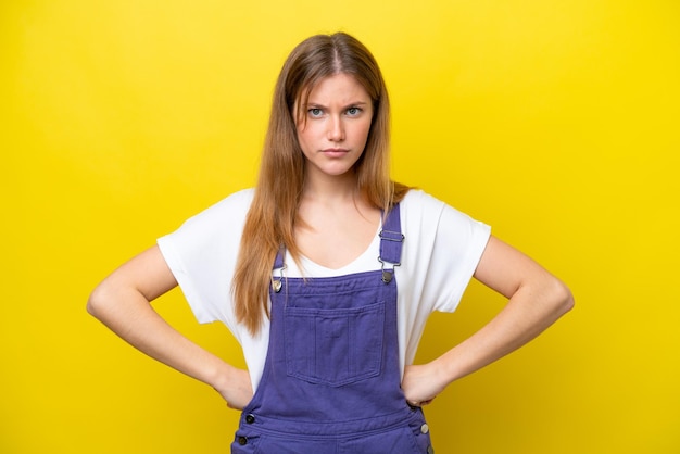 Young caucasian woman isolated on yellow background angry