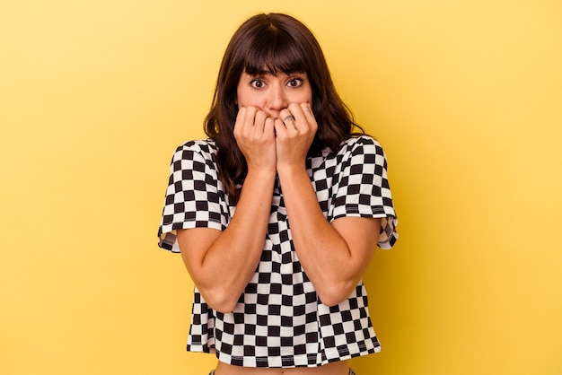 Young caucasian woman isolated on yellow background biting fingernails, nervous and very anxious.