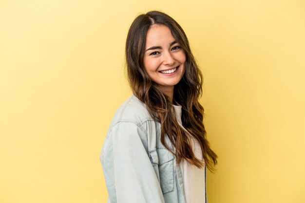 Young caucasian woman isolated on yellow background confident keeping hands on hips.