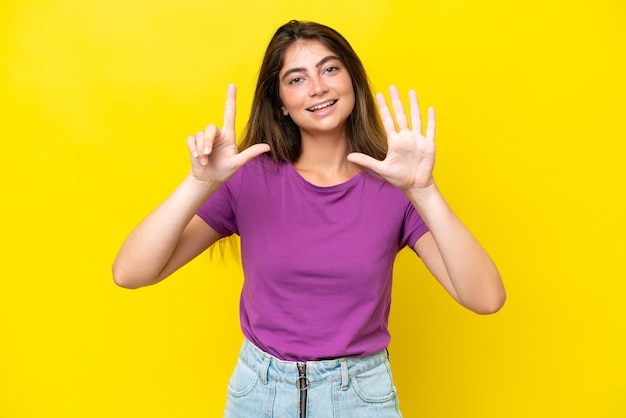 Young caucasian woman isolated on yellow background counting seven with fingers