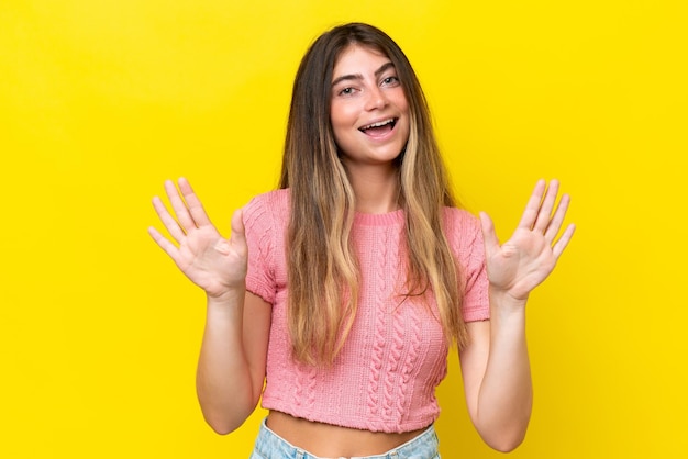 Young caucasian woman isolated on yellow background counting ten with fingers