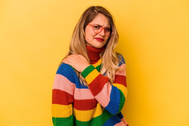 Young caucasian woman isolated on yellow background having a shoulder pain