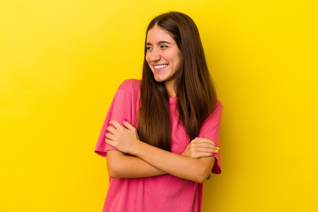 Young caucasian woman isolated on yellow background smiling confident with crossed arms.