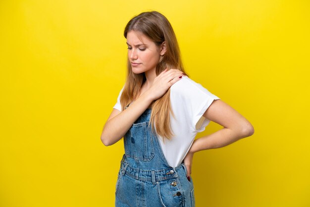 Young caucasian woman isolated on yellow background suffering from pain in shoulder for having made an effort