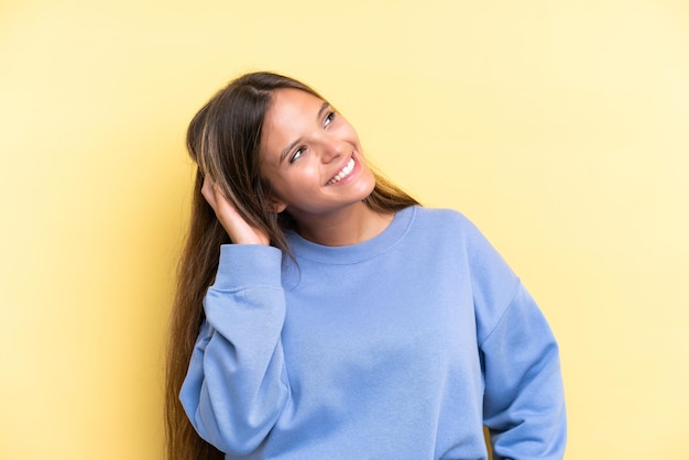 Young caucasian woman isolated on yellow background thinking an idea