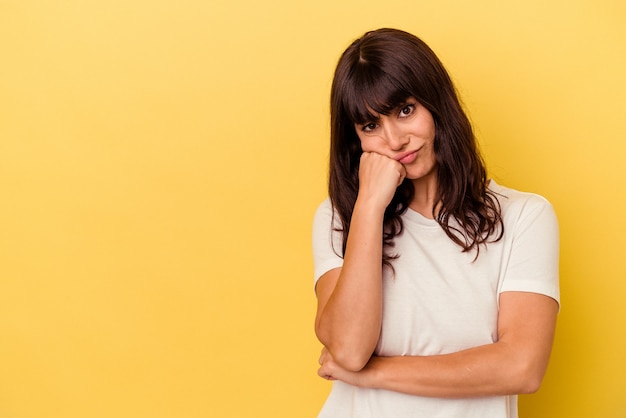 Giovane donna caucasica isolata su sfondo giallo che si sente triste e pensierosa, guardando lo spazio della copia.