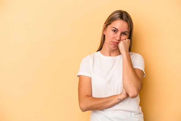 Young caucasian woman isolated on yellow background who feels sad and pensive, looking at copy space.