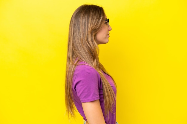 Young caucasian woman isolated on yellow background With glasses