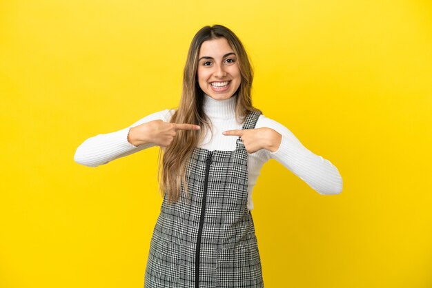 驚きの表情で黄色の背景に分離された若い白人女性