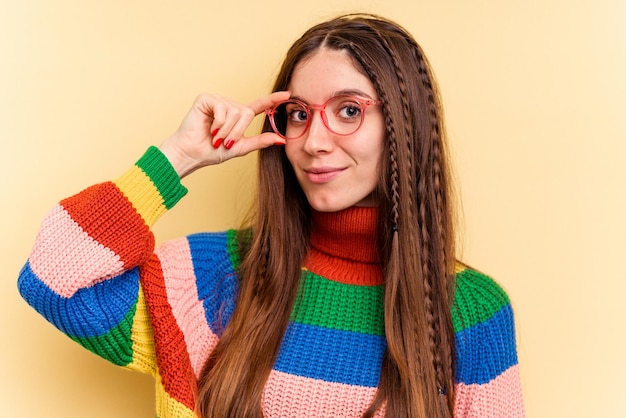 Young caucasian woman isolated on yellow background