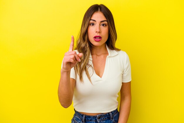 Young caucasian woman isolated on yellow background