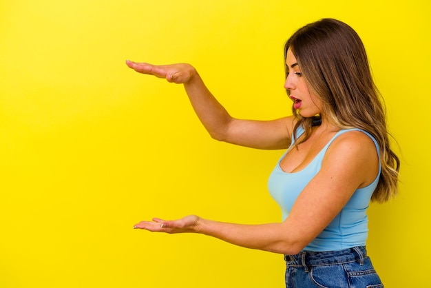 Young caucasian woman isolated on yellow background