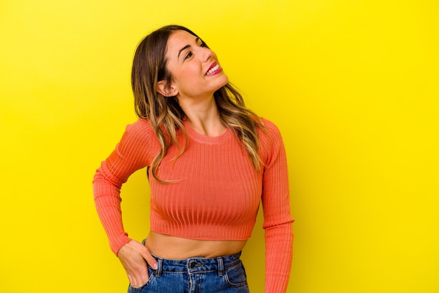 Young caucasian woman isolated on yellow relaxed and happy laughing, neck stretched showing teeth