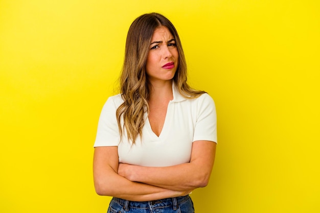 Young caucasian woman isolated on yellow unhappy looking in camera with sarcastic expression.