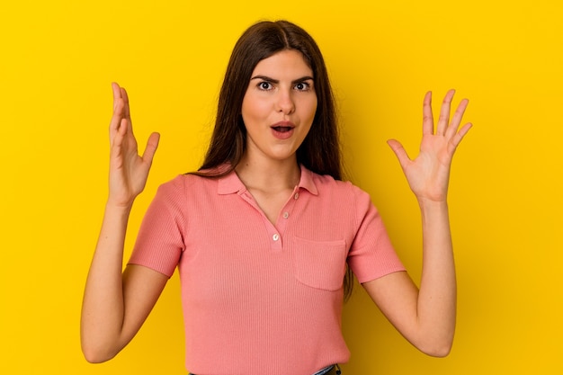 Young caucasian woman isolated on yellow wall having an idea