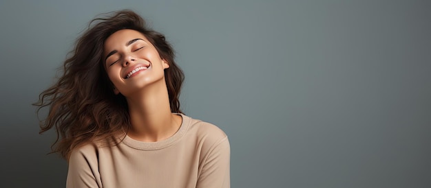 Young Caucasian woman laughing with closed eyes isolated on gray background Positive emotions