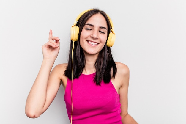 Young caucasian woman listening to music isolated on white background