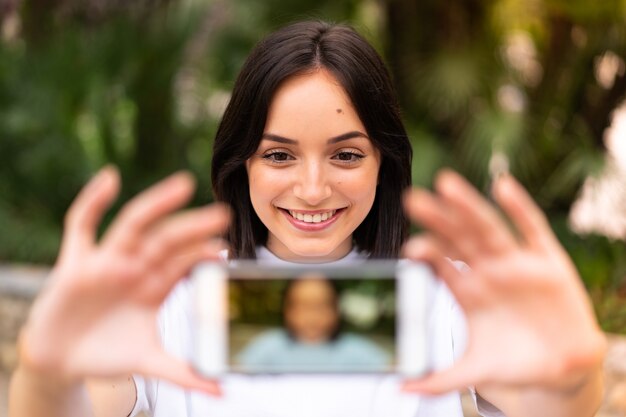 Giovane donna caucasica che fa un selfie all'aperto