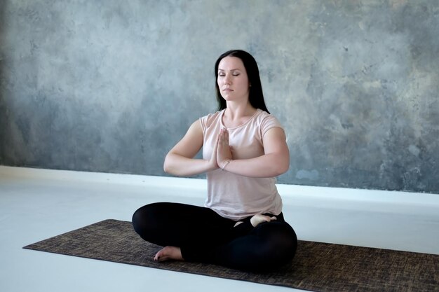 Young caucasian woman meditating on the floor