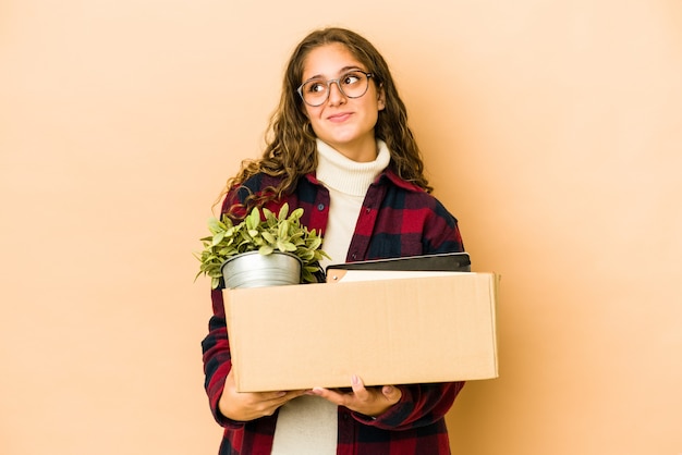 Young caucasian woman moving holding a box isolated