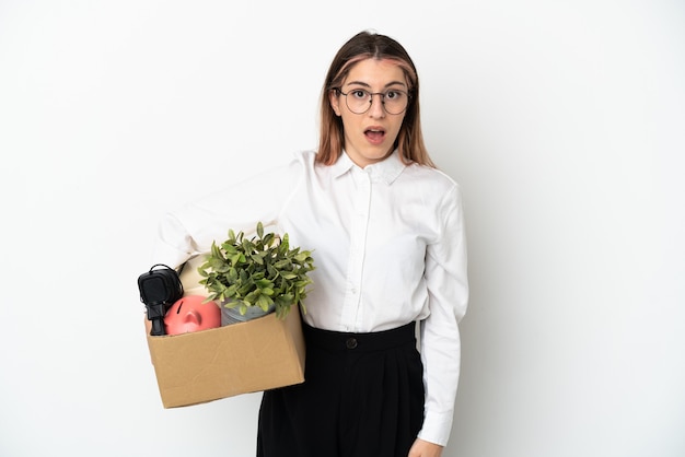 Young caucasian woman moving in new home among boxes isolated on white background with surprise facial expression