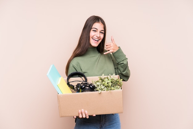 Young caucasian woman moving to a new home isolated showing a mobile phone call gesture with fingers