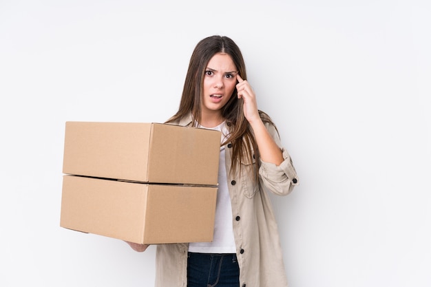 Young caucasian woman moving to a new home showing a disappointment gesture with forefinger.