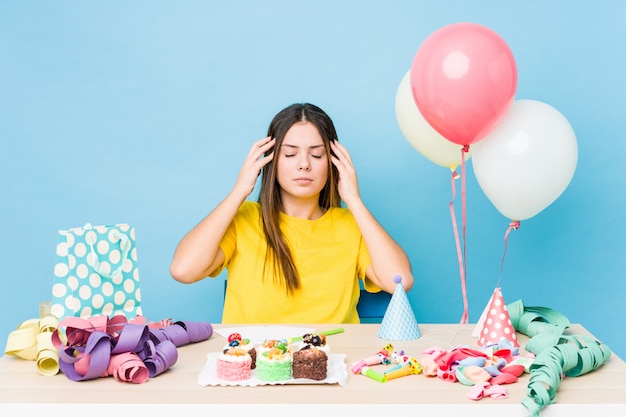 Young caucasian woman organizing a birthday and having headache.