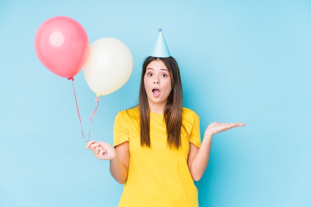 Young caucasian woman organizing a birthday isolated