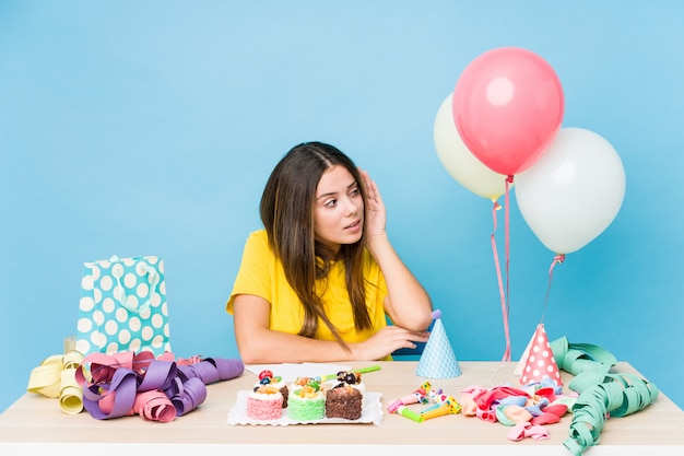 Young caucasian woman organizing a birthday trying to listening a gossip.