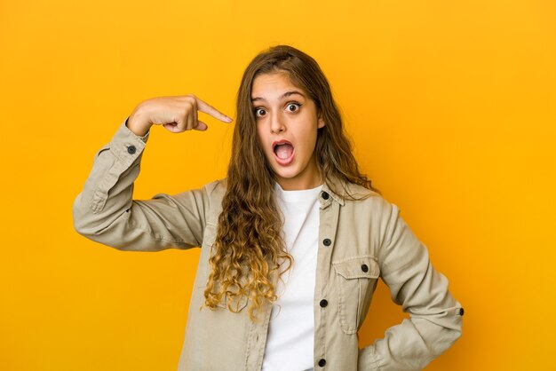 Young caucasian woman person pointing by hand to a shirt copy space, proud and confident